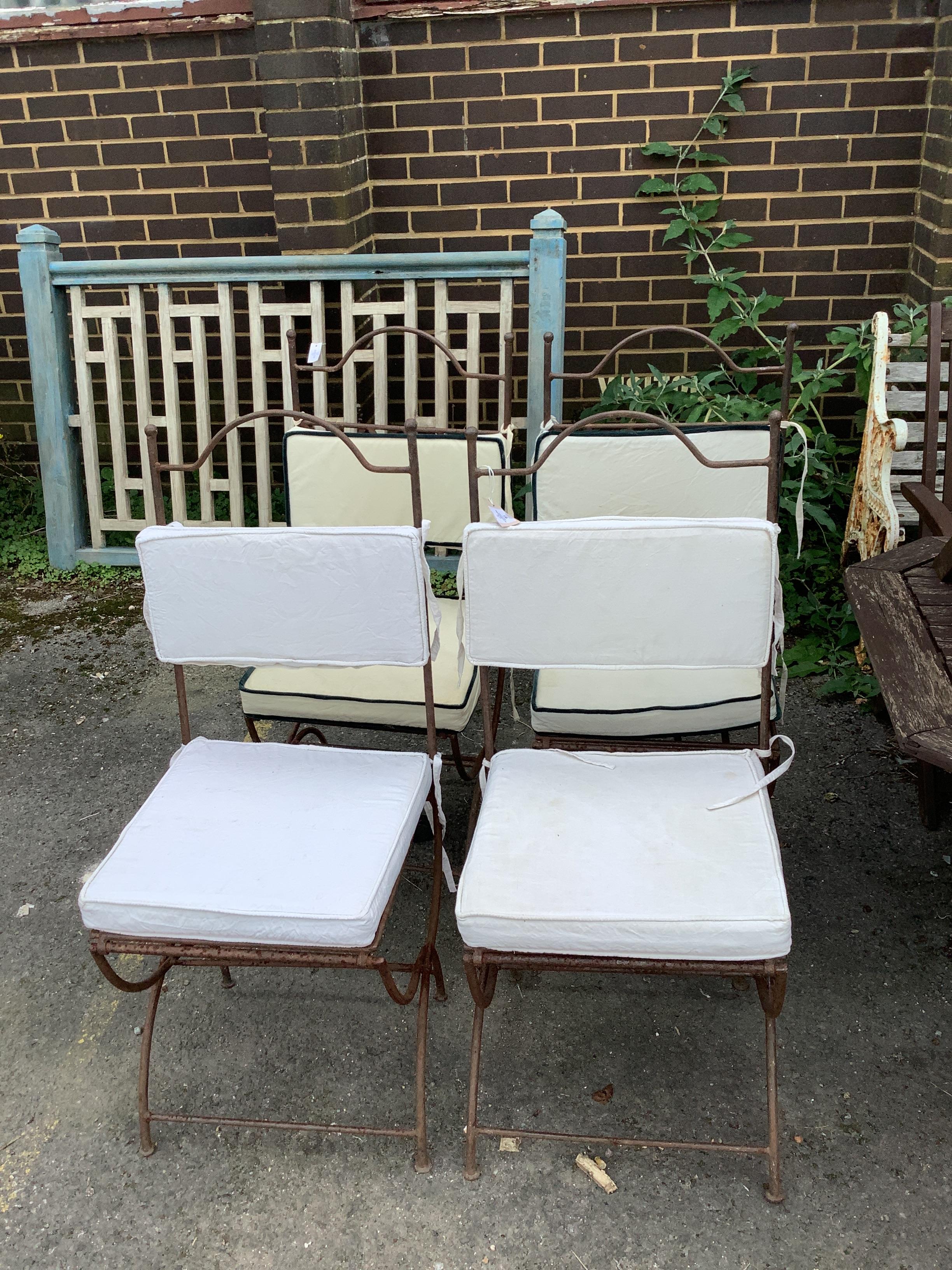 A set of four wrought iron folding garden chairs with seat pads, height 104cm